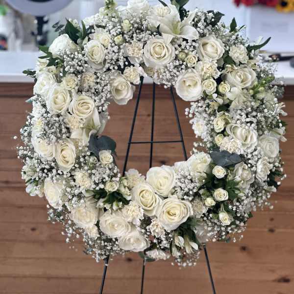 White rose wreath on a black stand