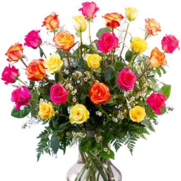 Mixed roses in pink, yellow, and orange arranged in a glass vase