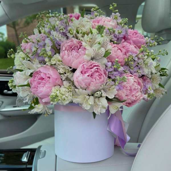 Pink peonies and white alstroemeria in a lavender hat box