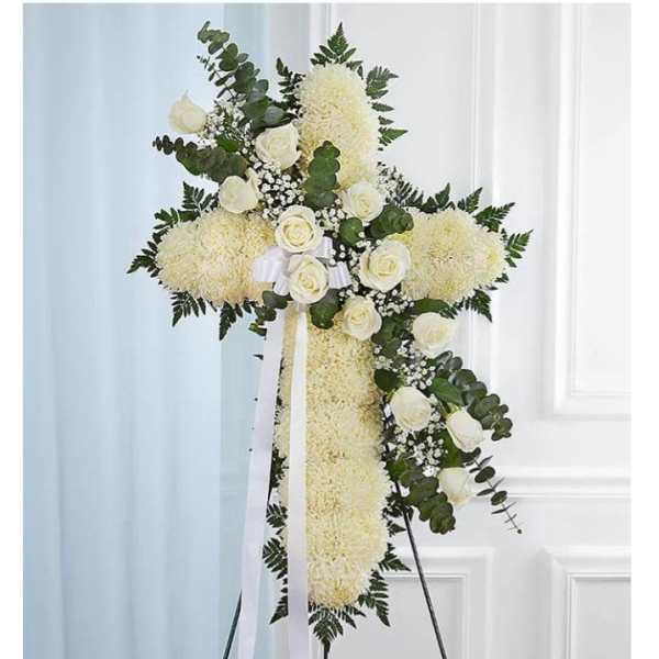 White floral standing cross on an easel with ribbon