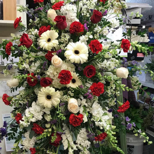 Large standing floral spray with red, white, and purple blooms
