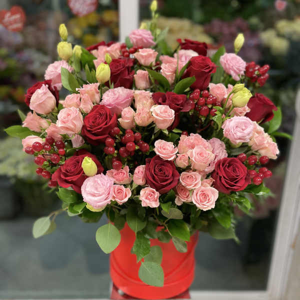 Bouquet of red and pink roses in a red hat box
