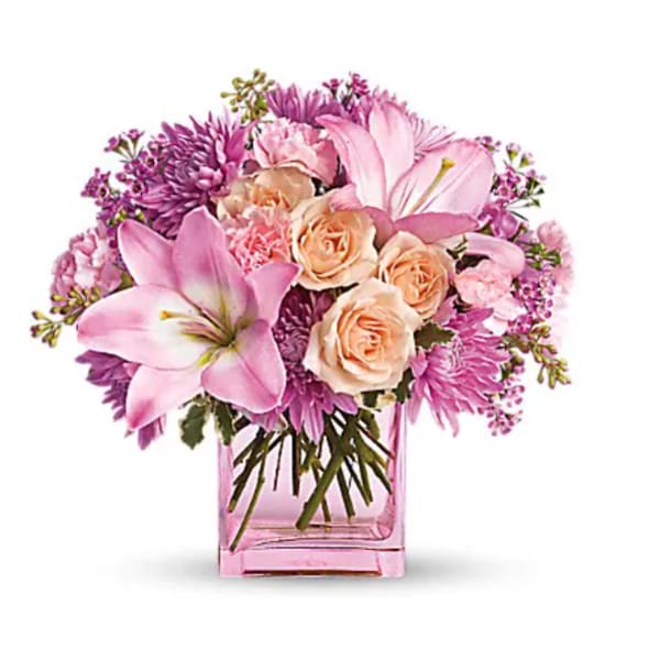 Pink and peach bouquet in a square glass vase