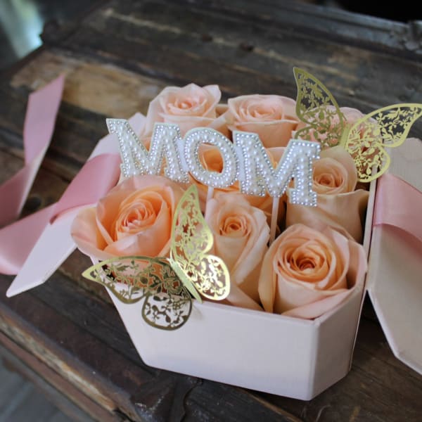 Peach roses in a pink gift box with a MOM topper and butterfly accents