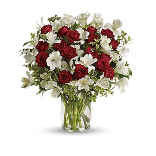 Red roses and white alstroemeria in a clear glass vase