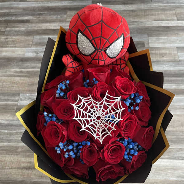 Spider-Man plush atop a bouquet of red roses with blue accents