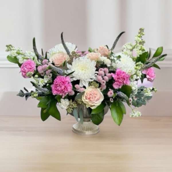 Pink and white floral arrangement in a silver vase
