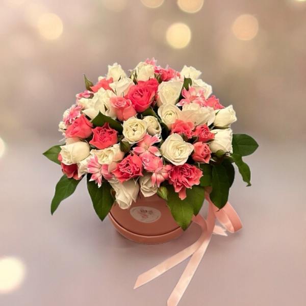 Pink and white rose bouquet in a round box with a ribbon