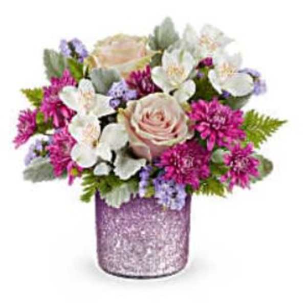 Pink and white flower arrangement in a glittery purple vase