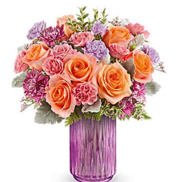 Bouquet of peach and pink roses in a purple glass vase