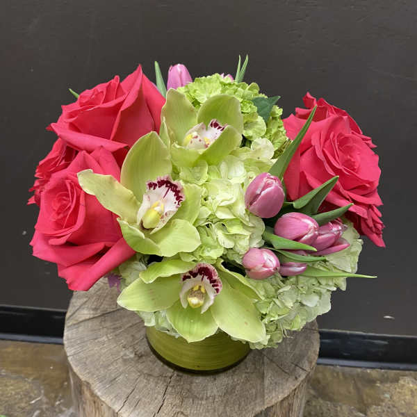 Pink roses and green orchids in a low vase arrangement
