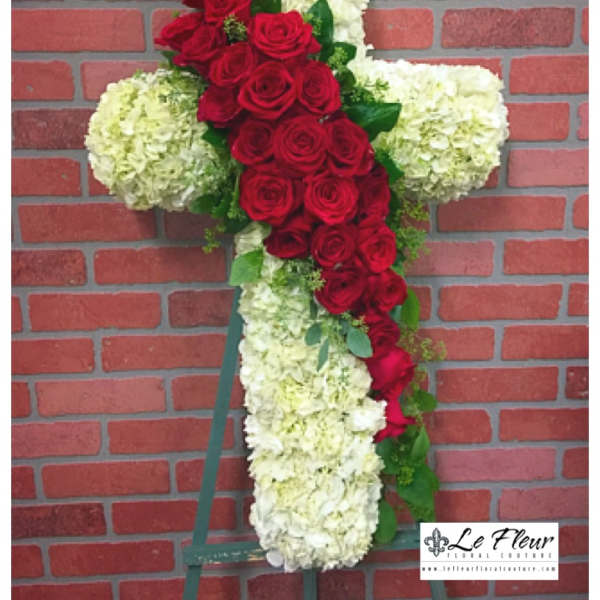Cross-shaped floral arrangement with red roses and white hydrangeas