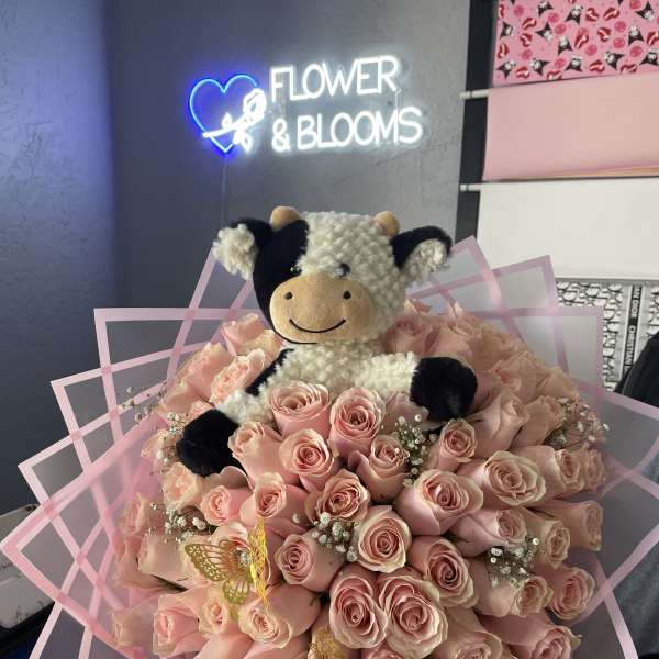 Pink rose bouquet with a plush cow topper and pink wrap