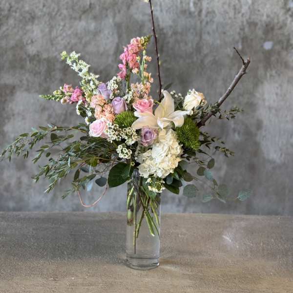 Mixed pastel flower arrangement in a clear glass vase