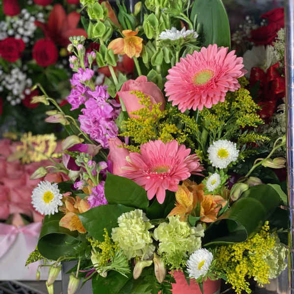 Mixed bouquet with pink gerberas, lilies, and purple blooms in a vase