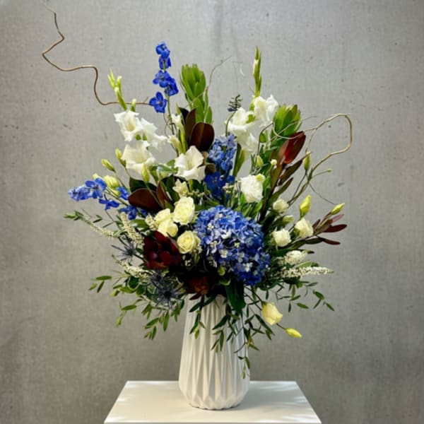 Blue and white floral arrangement in a white vase