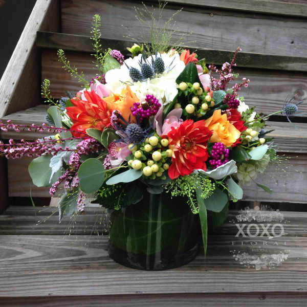 Colorful mixed flower arrangement in a dark vase
