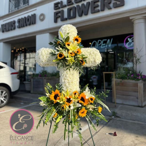 Large white floral standing cross with yellow and orange flowers
