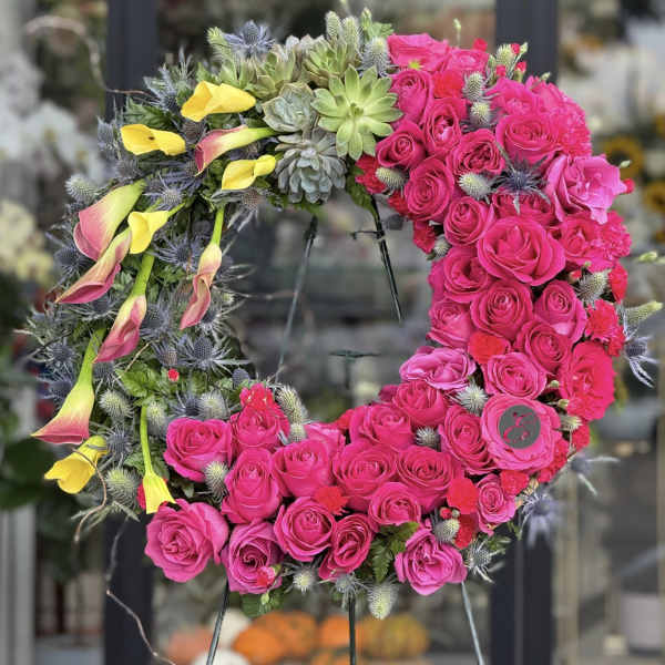 Heart-shaped floral wreath with pink roses, yellow calla lilies, and succulents