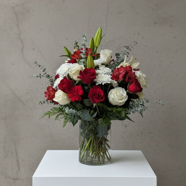 Red and white flower bouquet in a clear glass vase