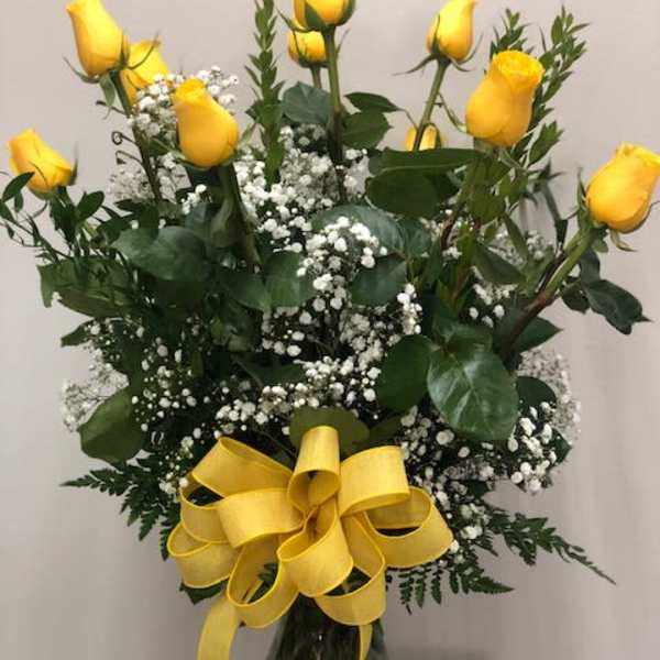Yellow roses with baby's breath in a glass vase and yellow ribbon