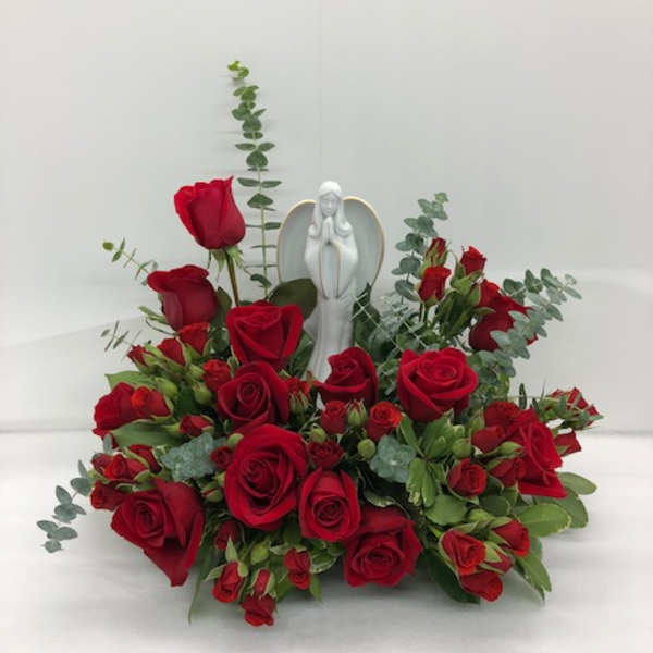 Red rose arrangement with an angel figurine in the center
