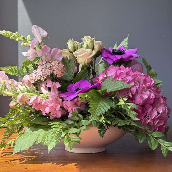 Pink and purple floral arrangement in a low bowl vase