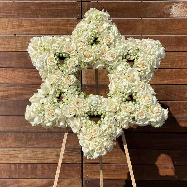 White floral arrangement shaped like a star on an easel
