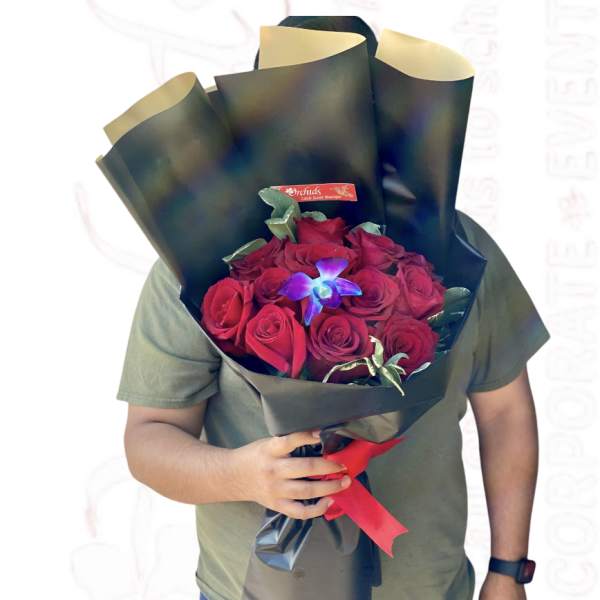 Bouquet of red roses wrapped in black paper with a red ribbon