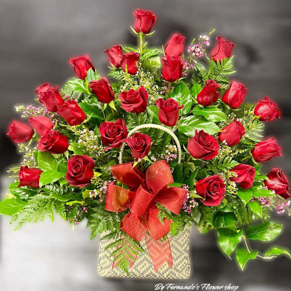 Large arrangement of red roses in a woven basket with a red bow