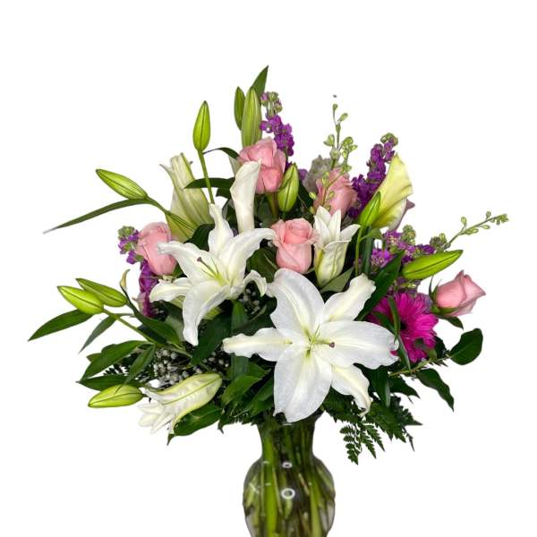 White lilies and pink roses arranged in a glass vase