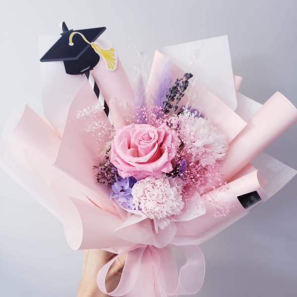 Pink rose bouquet with a graduation cap topper and pastel wrapping