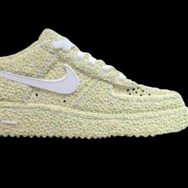 A pale yellow Nike sneaker covered in textured floral material