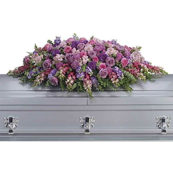 Lavender and pink floral casket spray on a silver casket