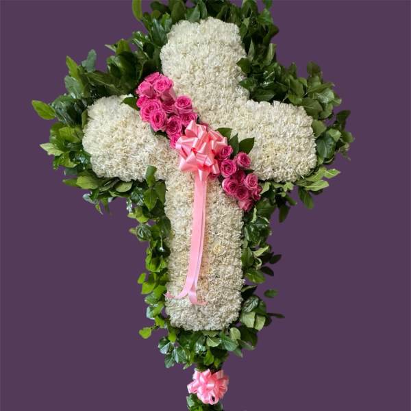 White floral cross with pink roses and ribbon on a purple background