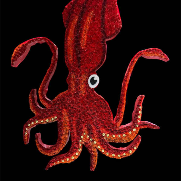 Red glitter squid-shaped decoration on a black background