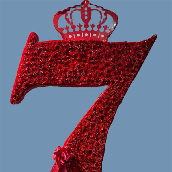 Red glitter crown-shaped decorative number seven with a ribbon bow