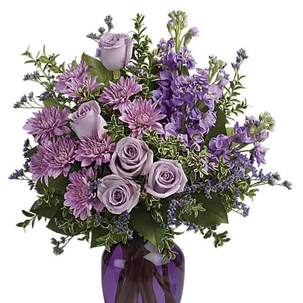 Lavender roses and purple flowers in a purple glass vase