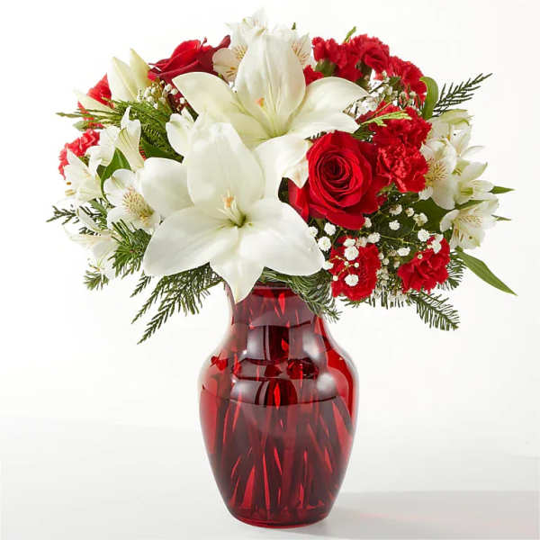 Red and white floral arrangement in a red glass vase