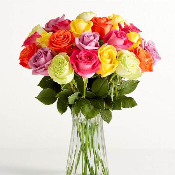 Colorful roses arranged in a clear glass vase