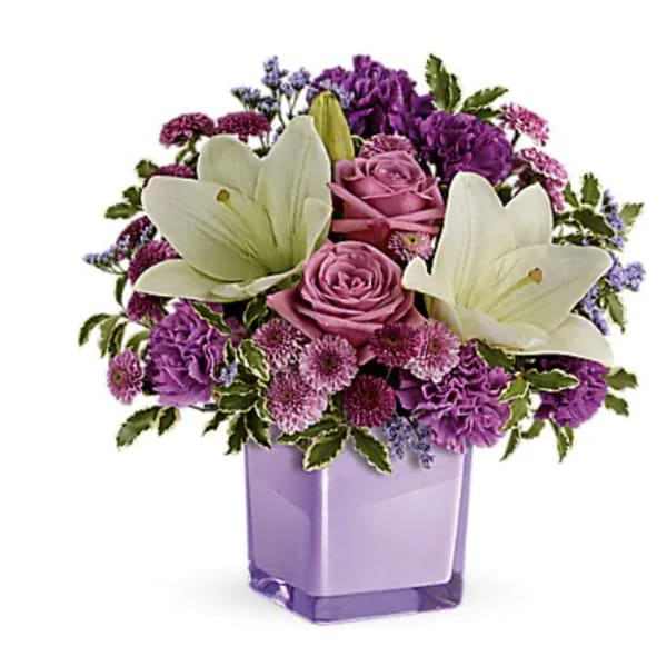 Purple and pink bouquet with white lilies in a lavender vase