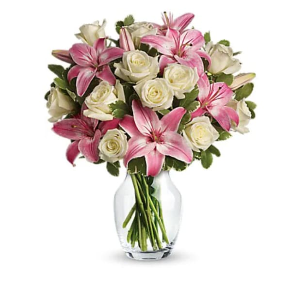 Pink lilies and white roses in a clear glass vase