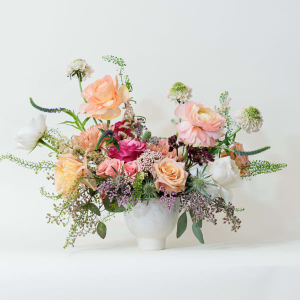 Mixed pastel flower arrangement in a white vase