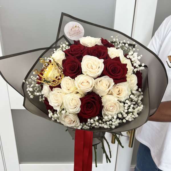 Bouquet of red and white roses with baby's breath and a gold crown