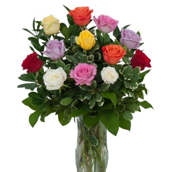 Mixed roses in a glass vase with dense greenery