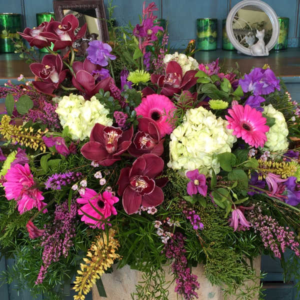 Large mixed floral arrangement with orchids, hydrangeas, and gerbera daisies