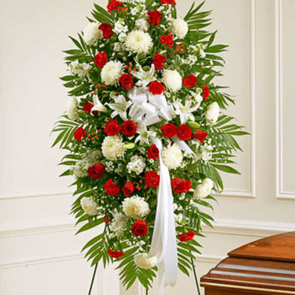 Standing floral spray with red and white flowers and a white ribbon