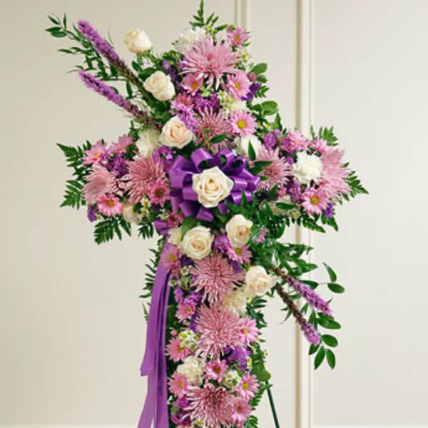 Standing floral spray with pink and white flowers and a purple ribbon