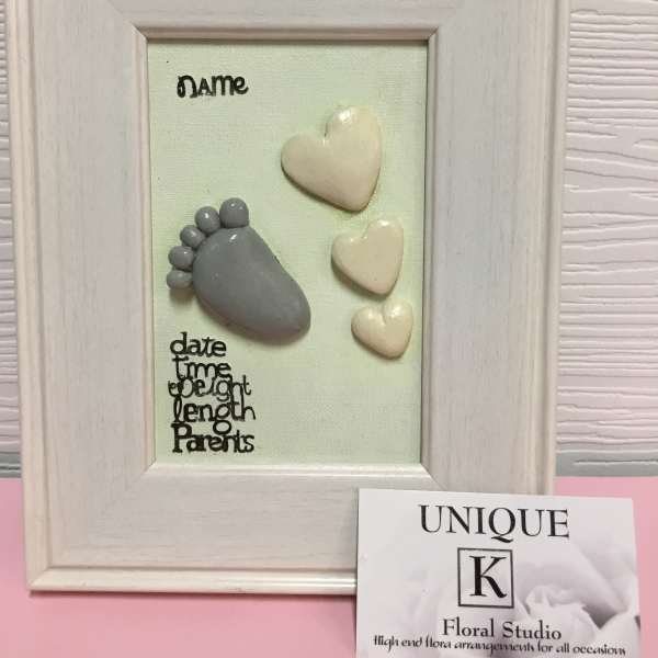 Framed keepsake with baby footprints and heart shapes