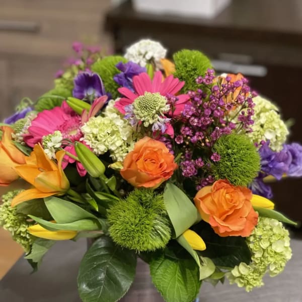 Colorful mixed bouquet with roses, lilies, and daisies in a vase